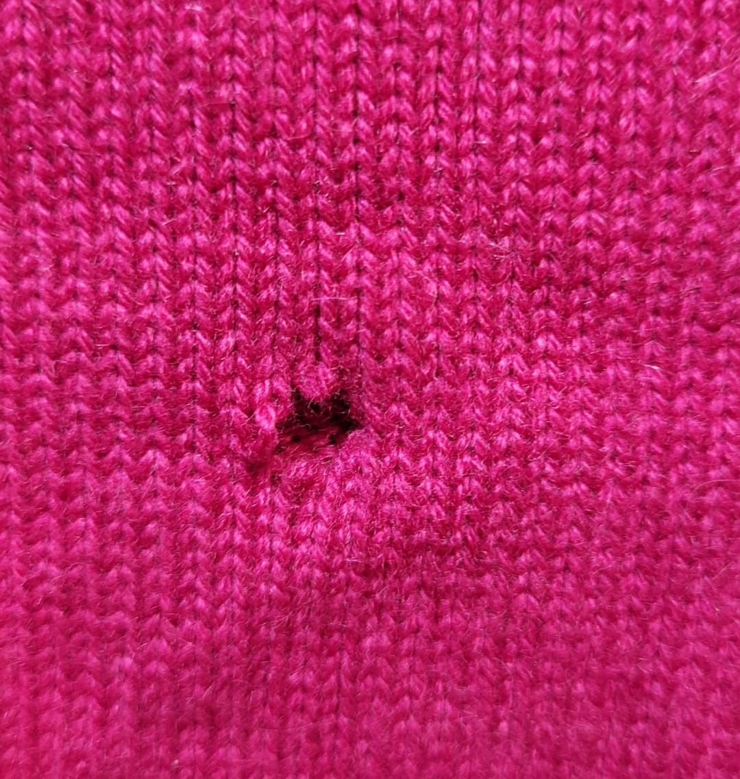 Pinker Strickpullover vorher – Mottenloch vor der Reparatur